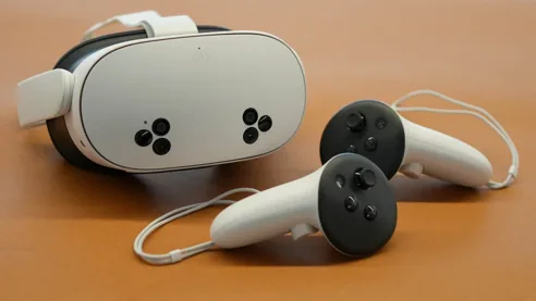 Casque de réalité virtuelle Meta Quest 3S posé sur un bureau avec ses deux manettes